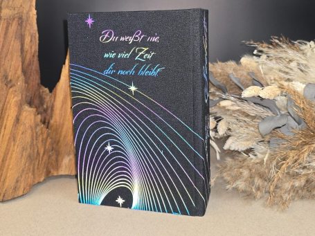 Seelen - Stephenie Meyer
Schwarzes Buch mit bunten geschwungenen Linien und Sternen auf einem neutralen Hintergrund.