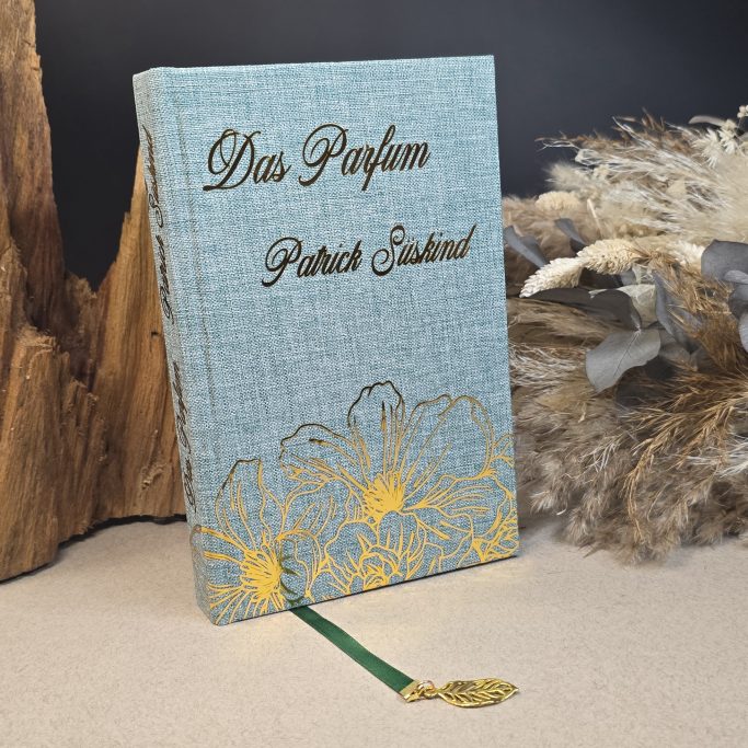 Ein gebundenes Buch mit goldener Schrift und floralen Mustern auf einem blauen Einband.