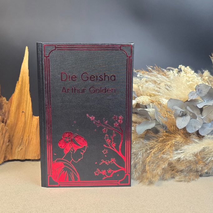 Das Buch "Die Geisha" von Arthur Golden, mit roten und goldenen Verzierungen.
