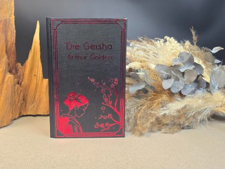 Ein schwarzes Buch mit rotem Titel und verzierter Darstellung von Pflanzen.