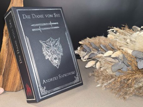 The Witcher - Pentalogie - Andrezj Sapkowski Buchcover von "Die Dame vom See" mit einem Wolfssymbol und einem eleganten Design.
