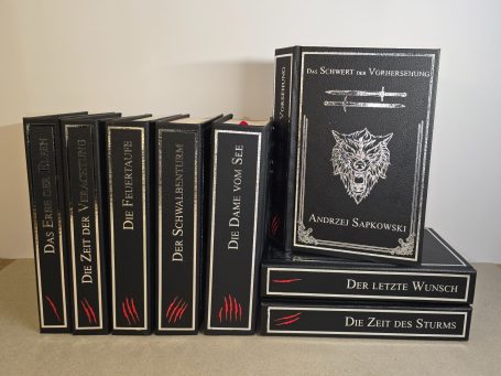 Schwarze Buchreihe mit rotem und silbernem Schriftzug, mehrere Bände gestapelt.