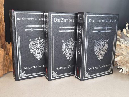 The Witcher - Kurzgeschichten - Andrzej Sapkowski&nbsp;Drei schwarze Bücher mit silbernen Schriftzügen und Wappen auf dem Einband.