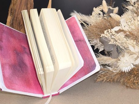 Eat Pray Love – Elizabeth Gilbert
Ein offenes Buch mit Seiten, daneben getrocknete Pflanzen.